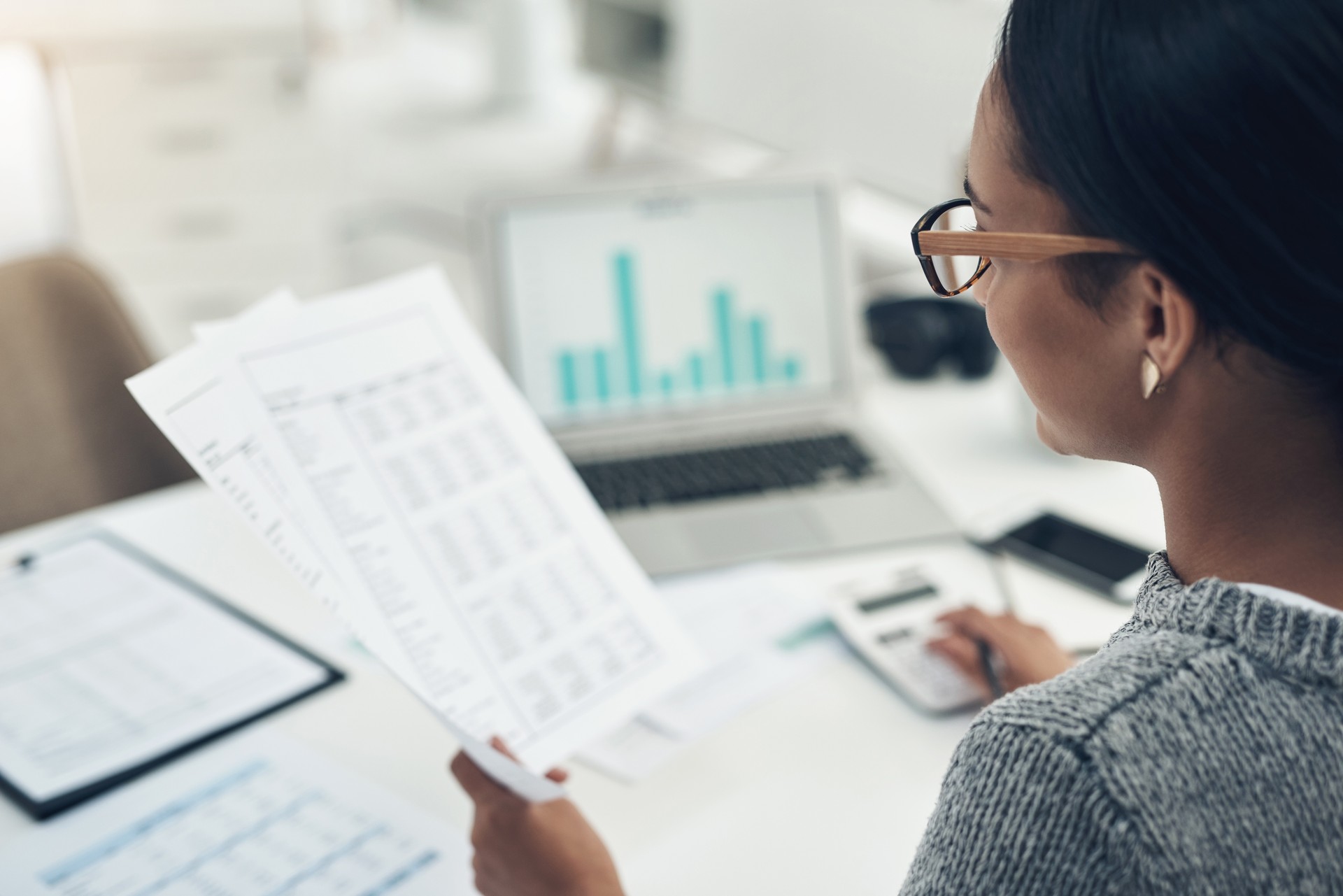 Nahaufnahme einer nicht wiederzuerkennenden Geschäftsfrau, die in einem Büro Finanzen berechnet